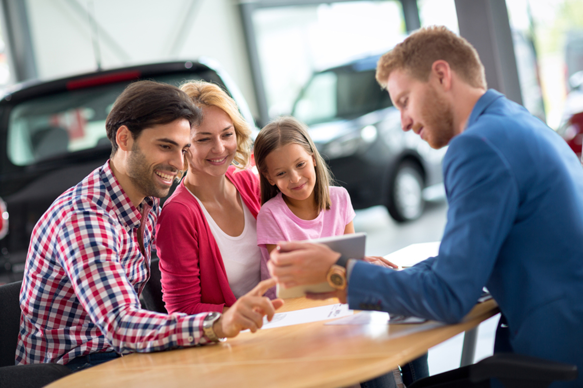 Happy family with a car salesman.